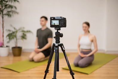 two people doing yoga in front of camera which is on a tripod