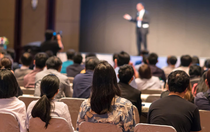 person taking to a group of people in a corporate meeting