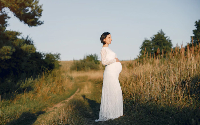 lady standing alone by holding her womb